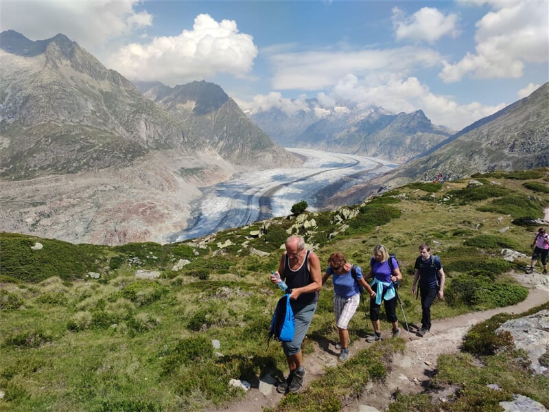 Turista pije vodu na túře v horách