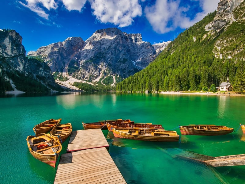 Dřevěné loďky u mola na jezeře Lago di Braies pod horou Seekofel