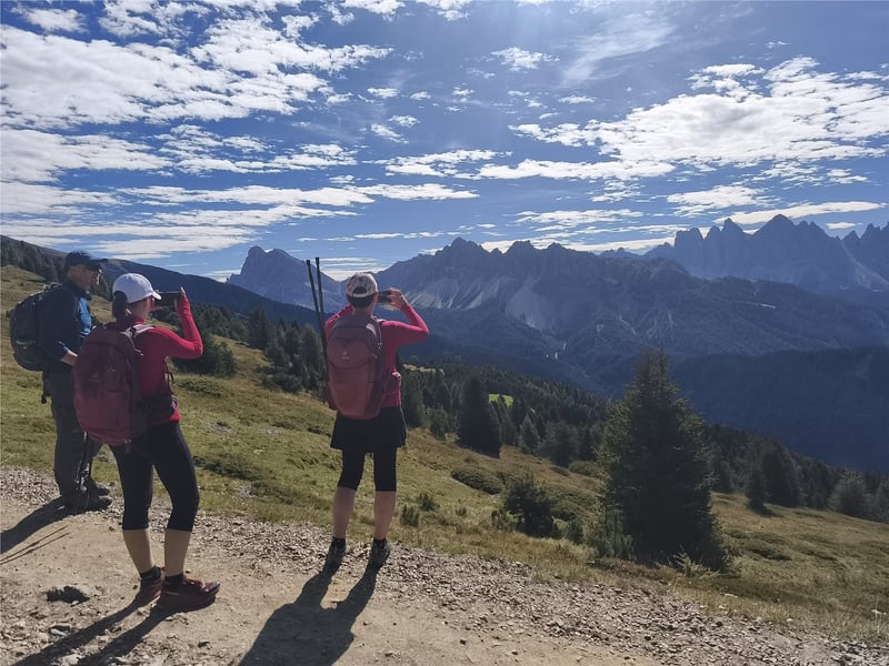 Turisté fotí výhled z Plose na skalní štíty Dolomit